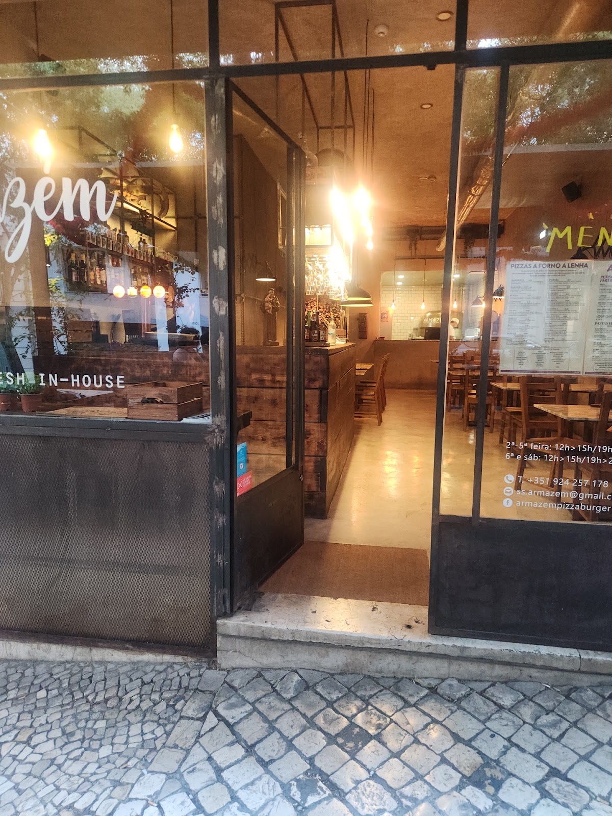 Entrada de vidro iluminada do restaurante Armazém