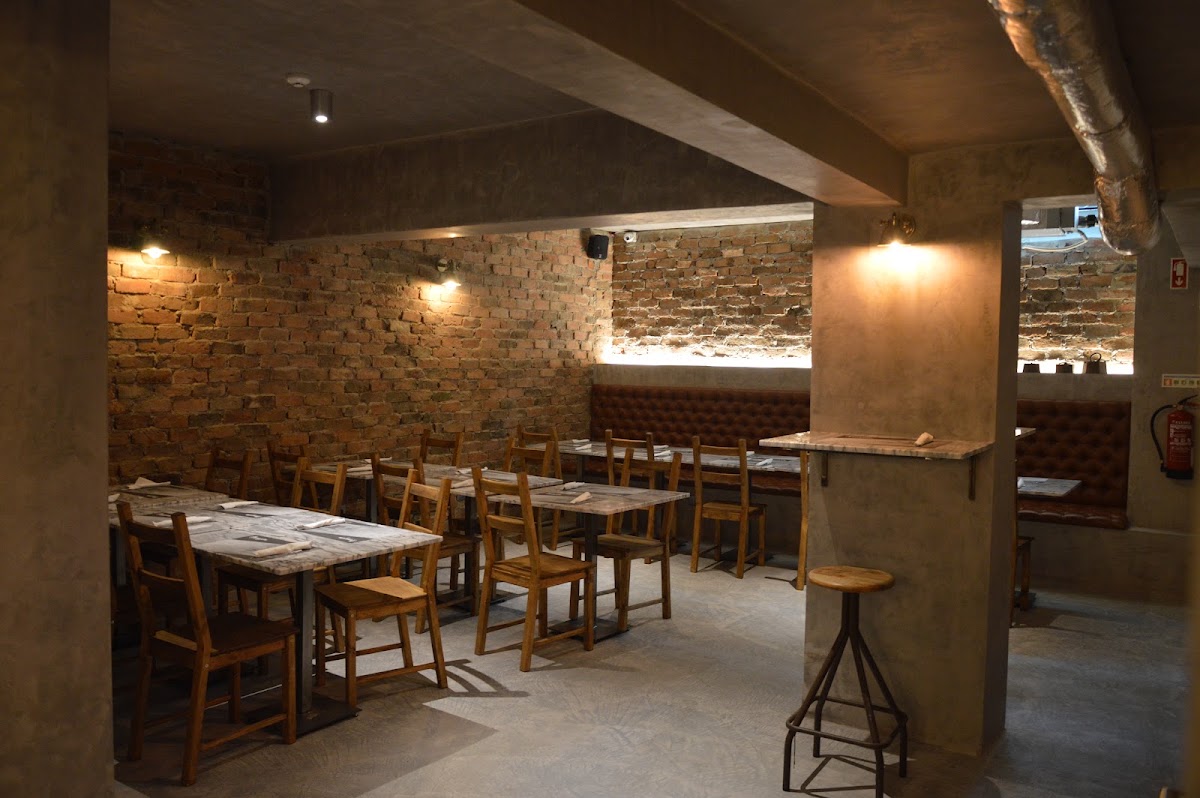 Sala de jantar com paredes de pedra e luz quente no Armazém